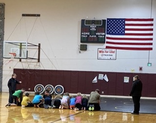 students preparing to practice wrestling in the gym