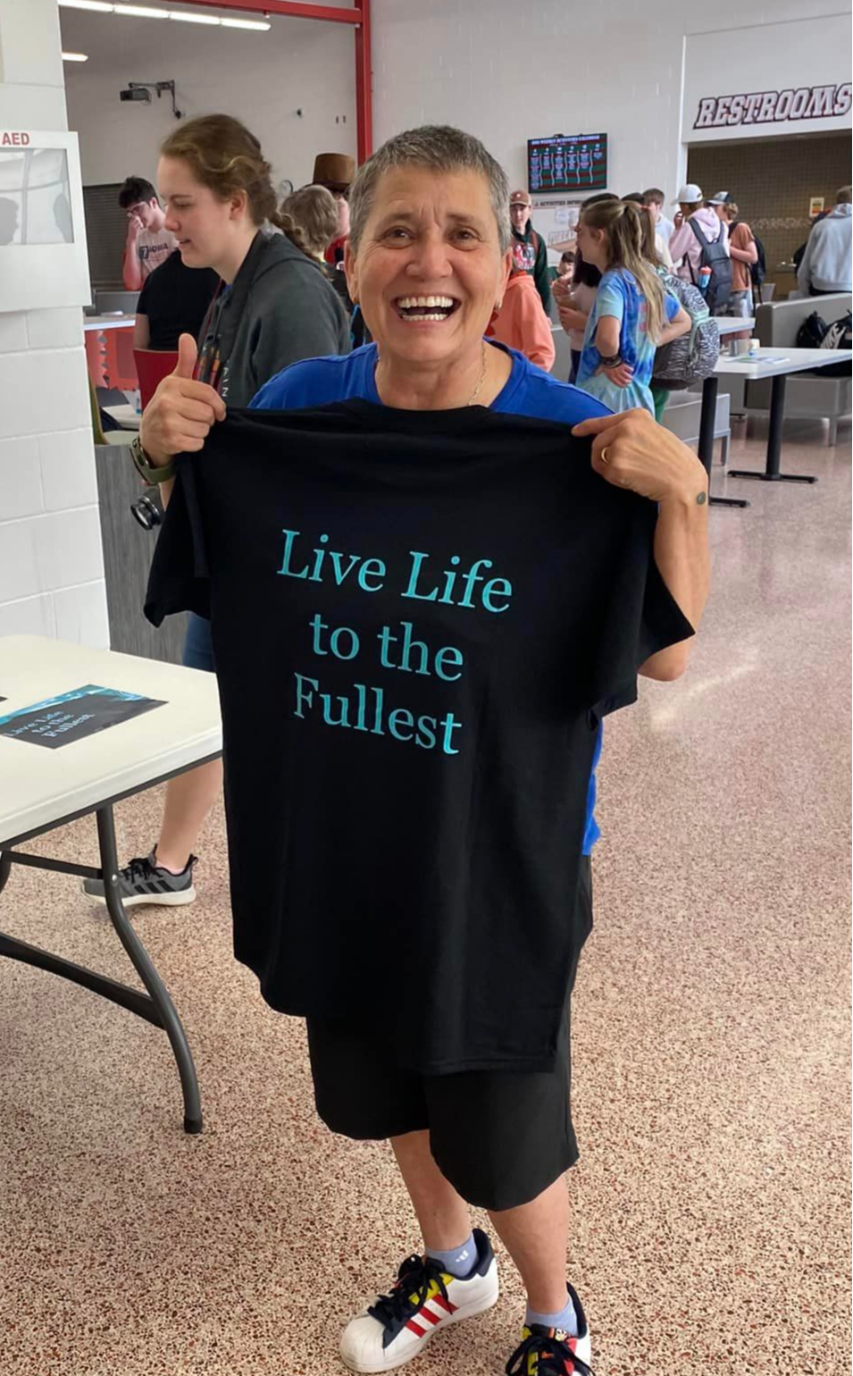 Kim Kitterman posing with a shirt that says Live life to the fullest 