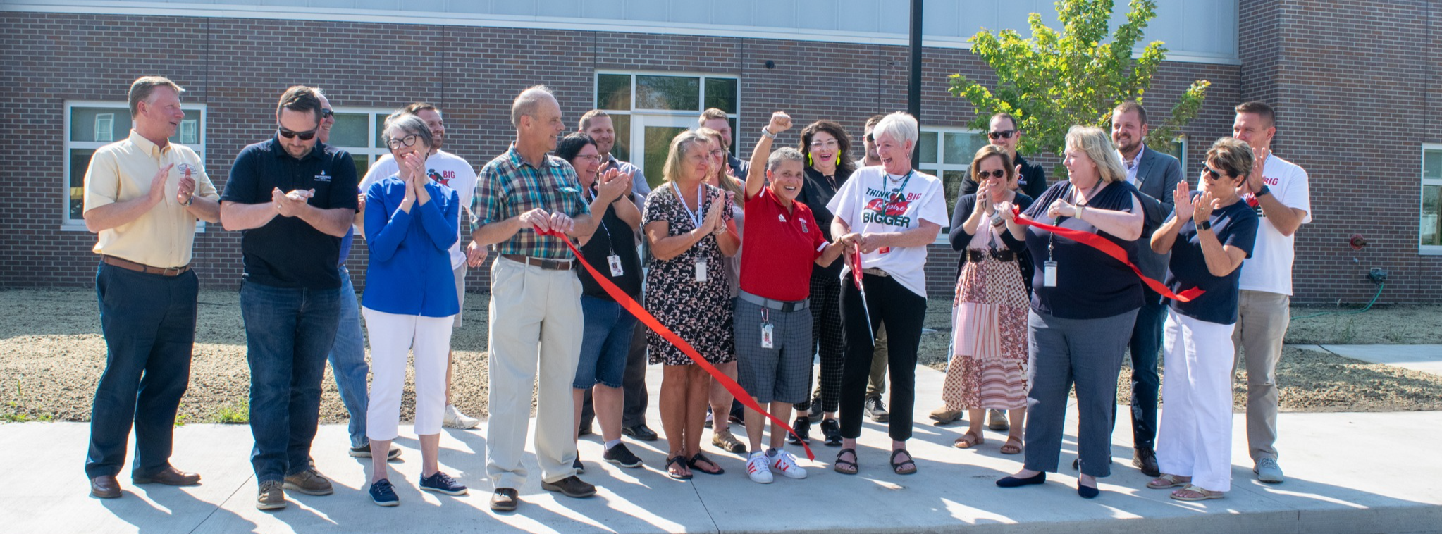 Futures Alternative High School ribbon cutting ceremony - a crowd standing in front of the building Director Kim Kitterman cutting the red ribbon