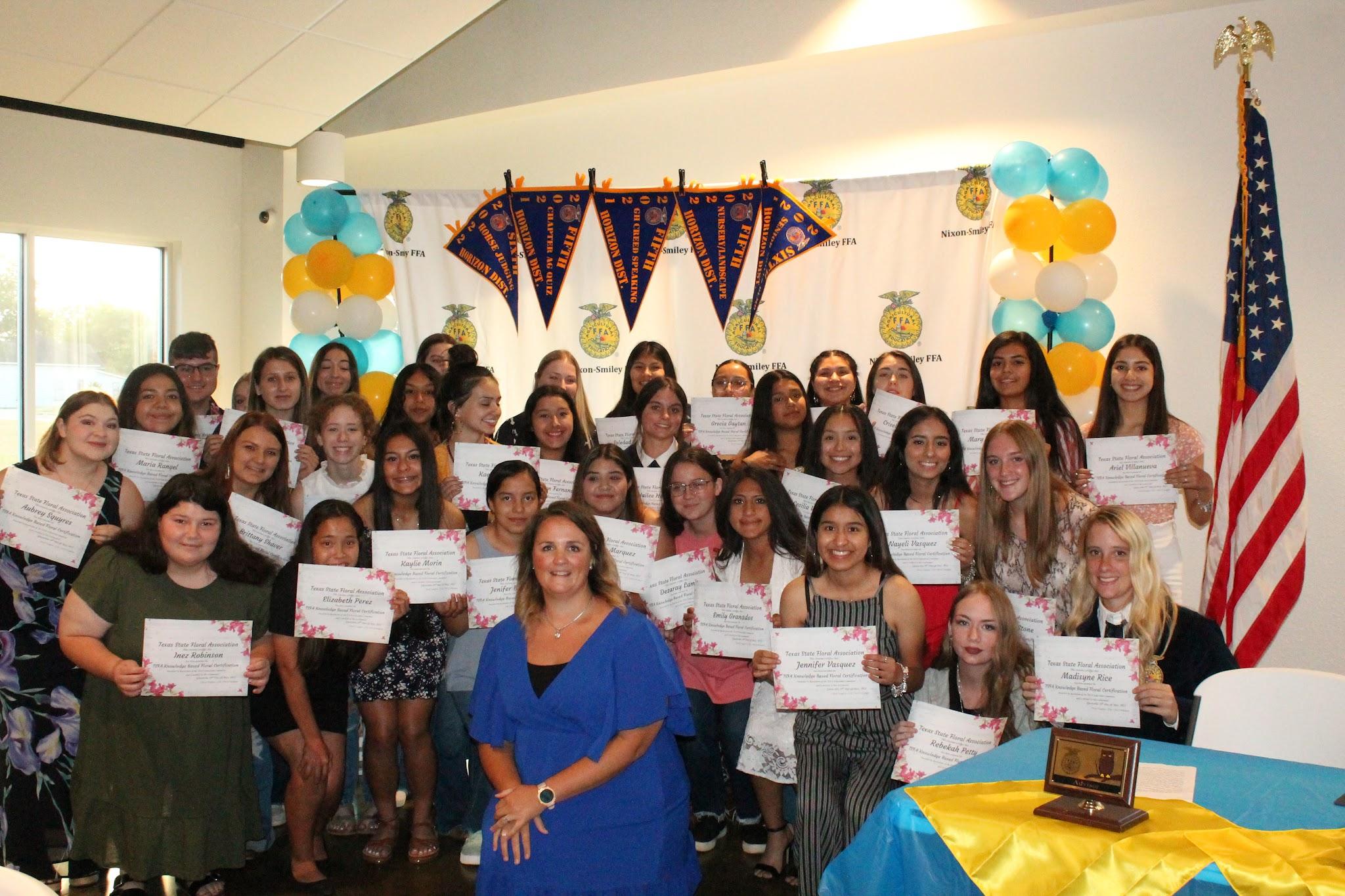 group of students holding certificates of achievement