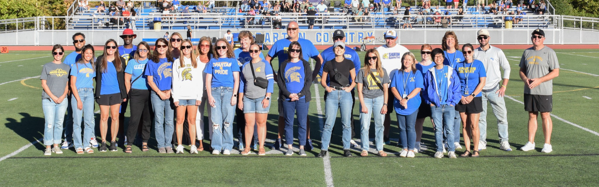 staff standing together on football field