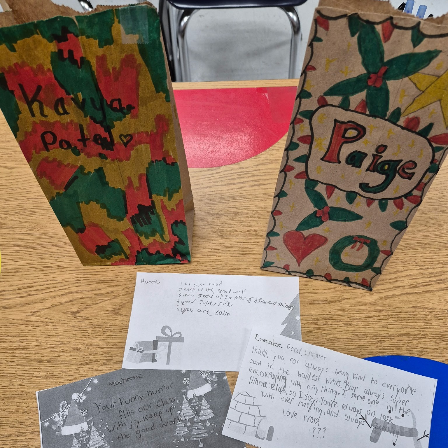 Hand-decorated paper bags and handwritten notes filled with positive affirmations from students, created during a Secret Santa activity to celebrate kindness and encouragement in the classroom.