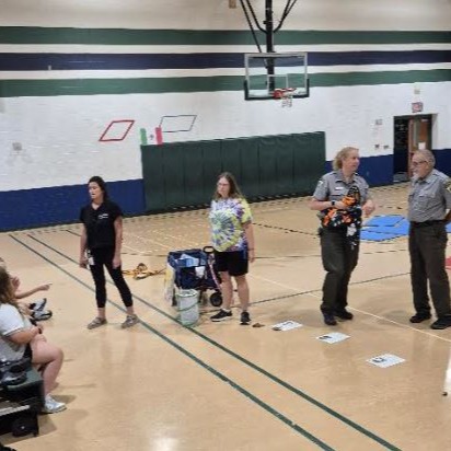 Park services speak with scholars during a school gym presentation.