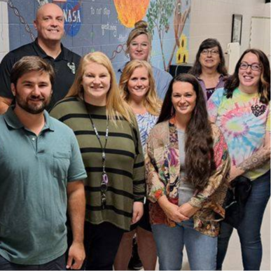 group of new teachers smile in hallway