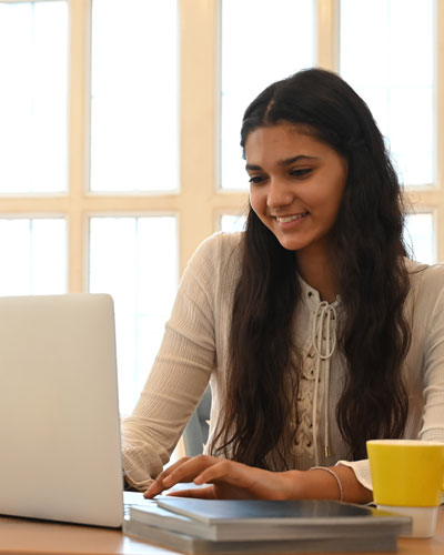 Teenage girl at laptop doing remote learning program