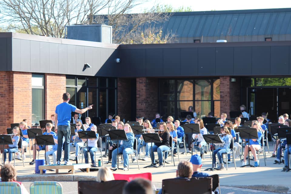 Picture of Plainwell Middle School band concert outside in front of Plainwell Middle School.  Students are wearing blue shirts.