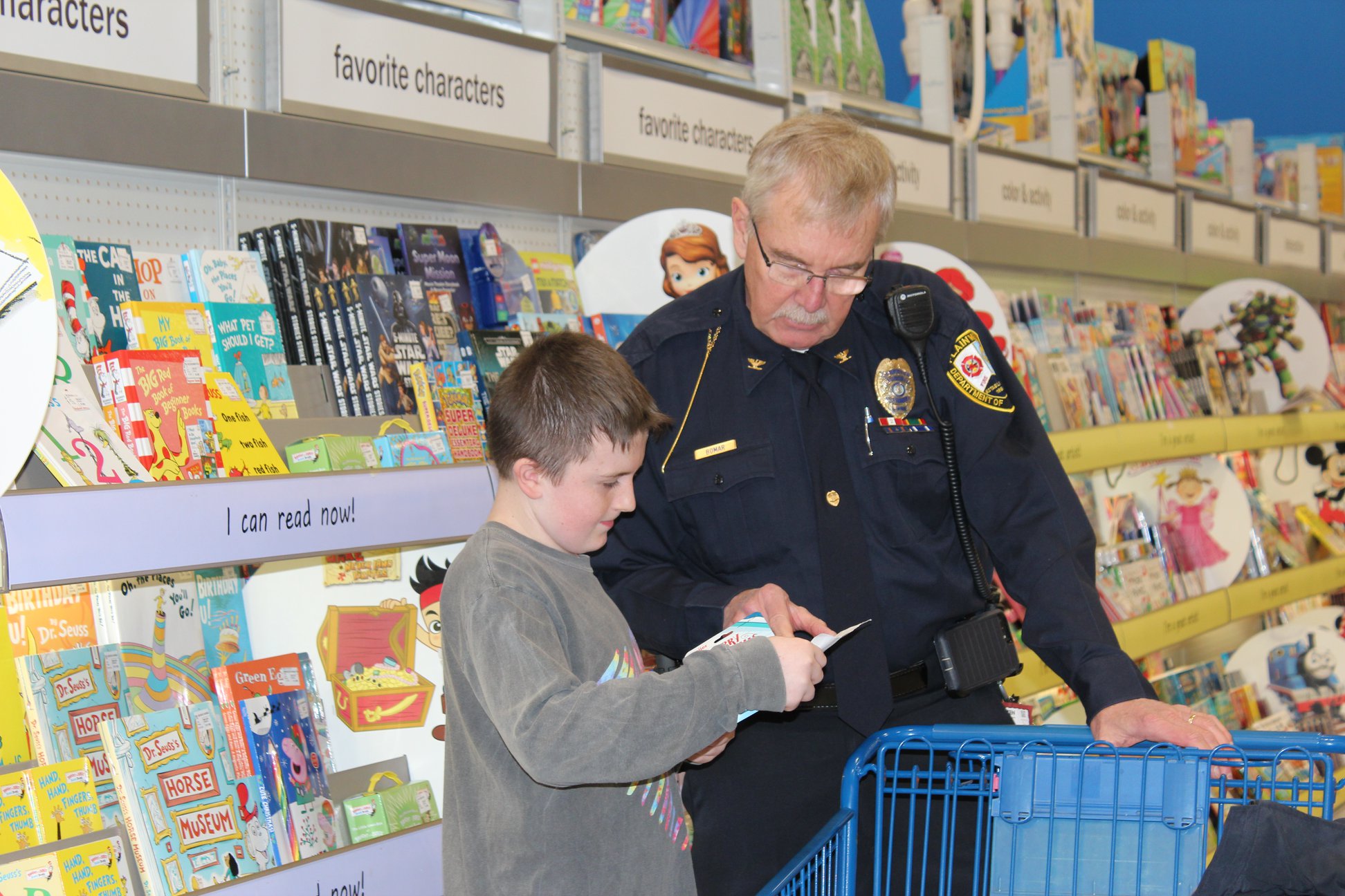 Picture of a police officer helping a student shopping at Meijer for the annual Shop with a Hero event.