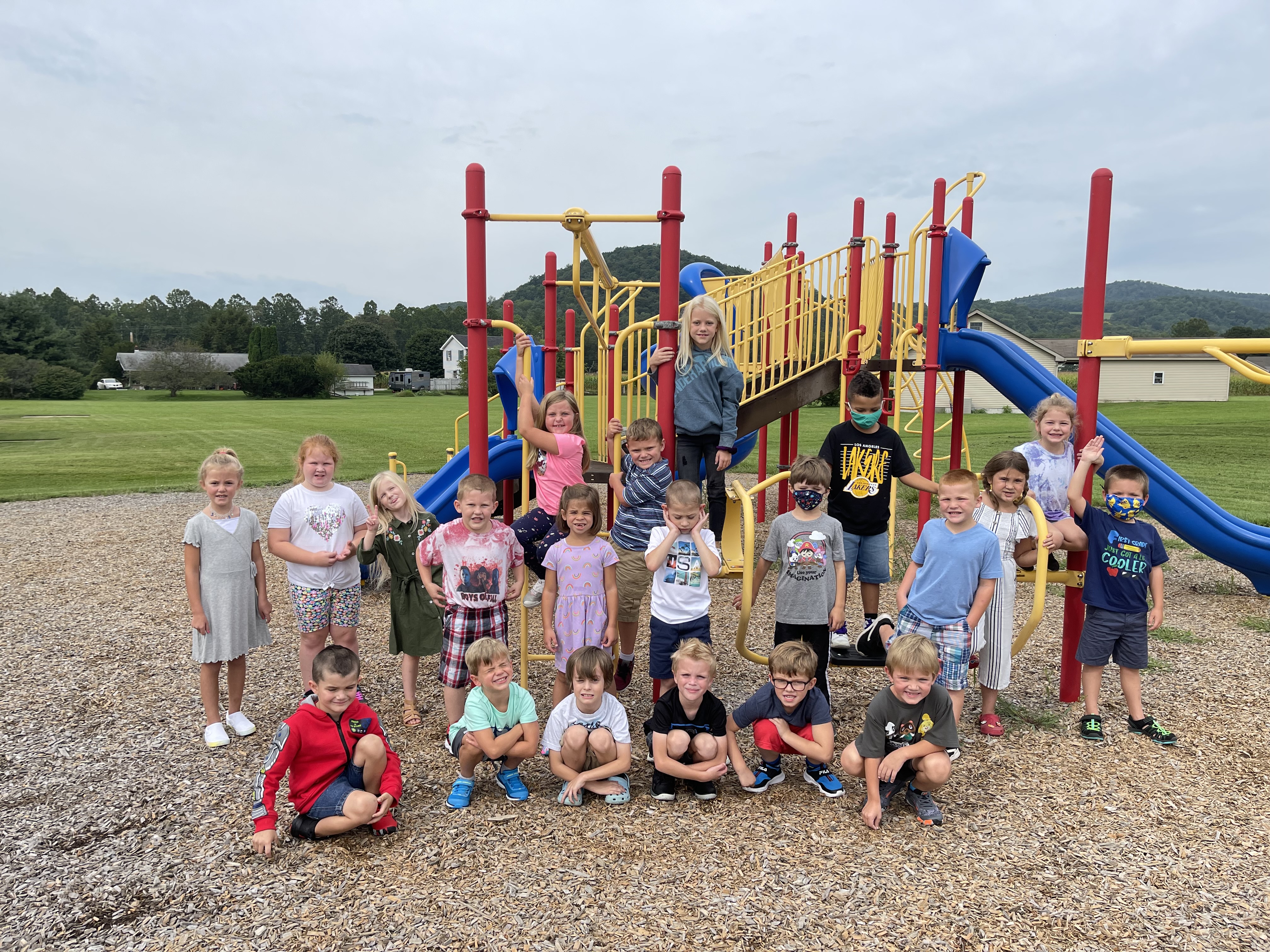 Two rows of students standing in front of the playground.