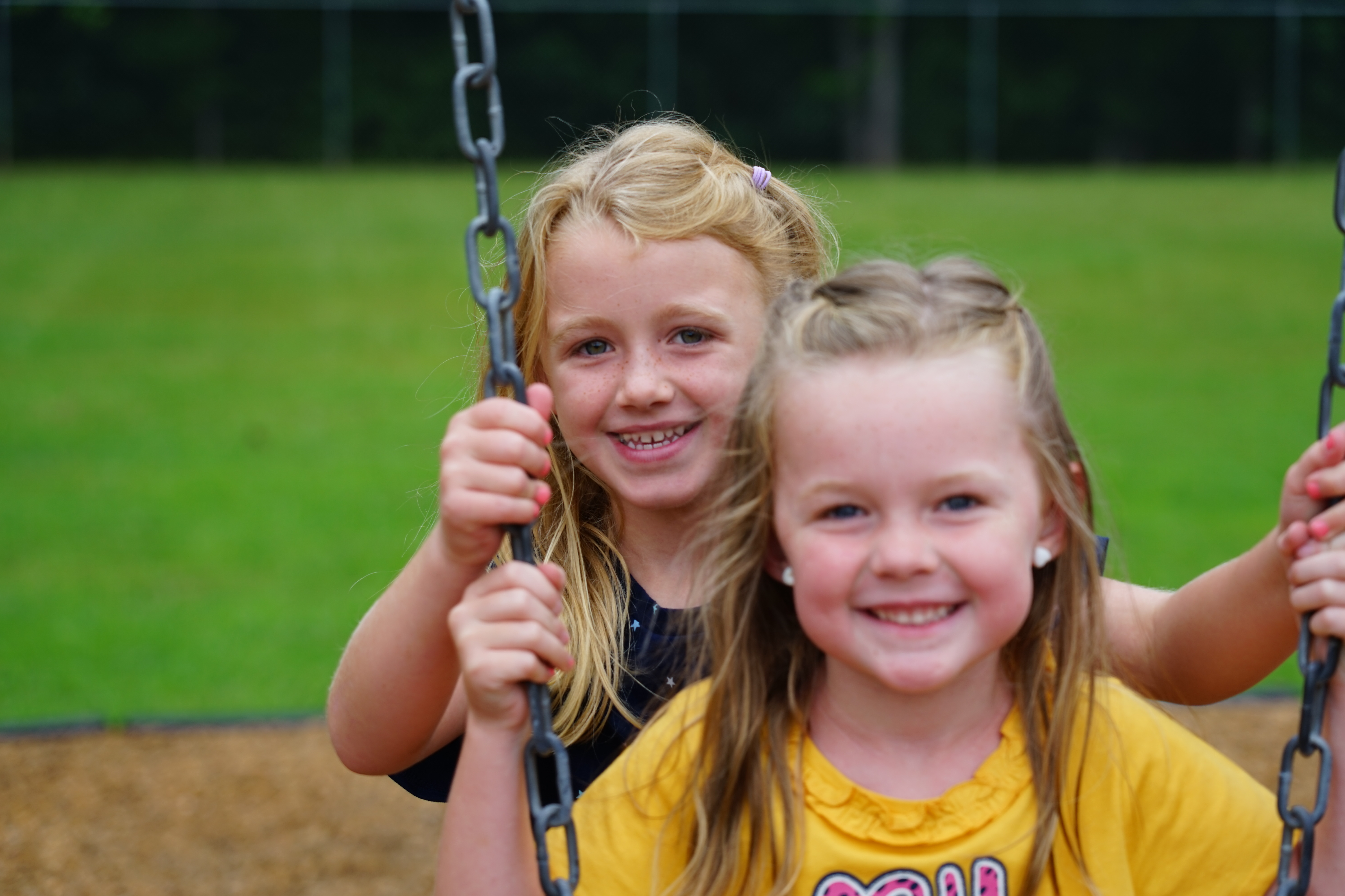Two girls on swing at recess
