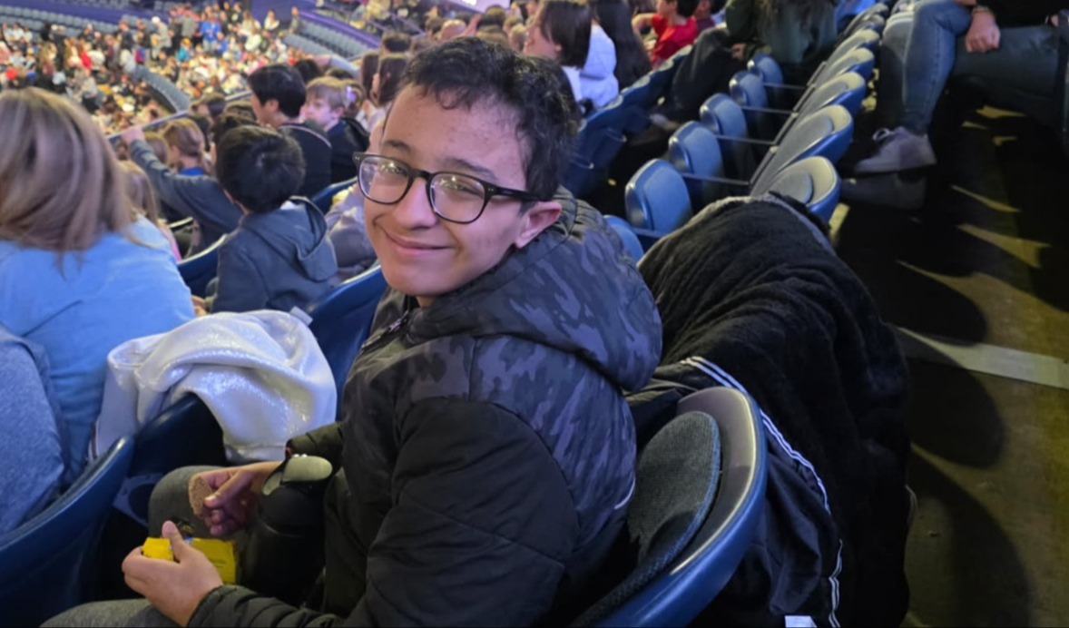 Smiling student sitting in bleachers at Chicago Wolves hockey game