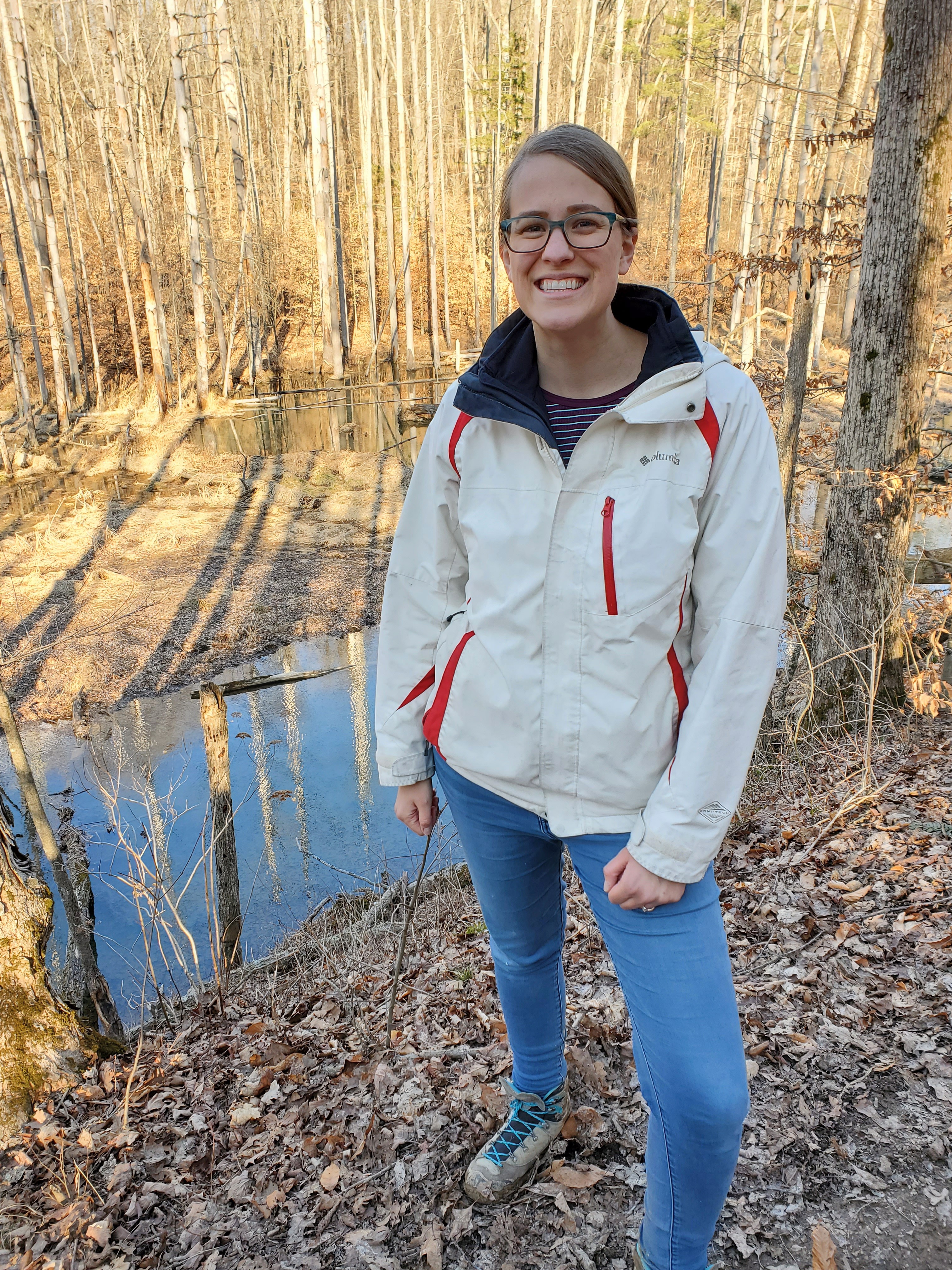 Mrs. Cummins is standing in front of a lake in Morgan-Monroe State Park while enjoying a hike. 
