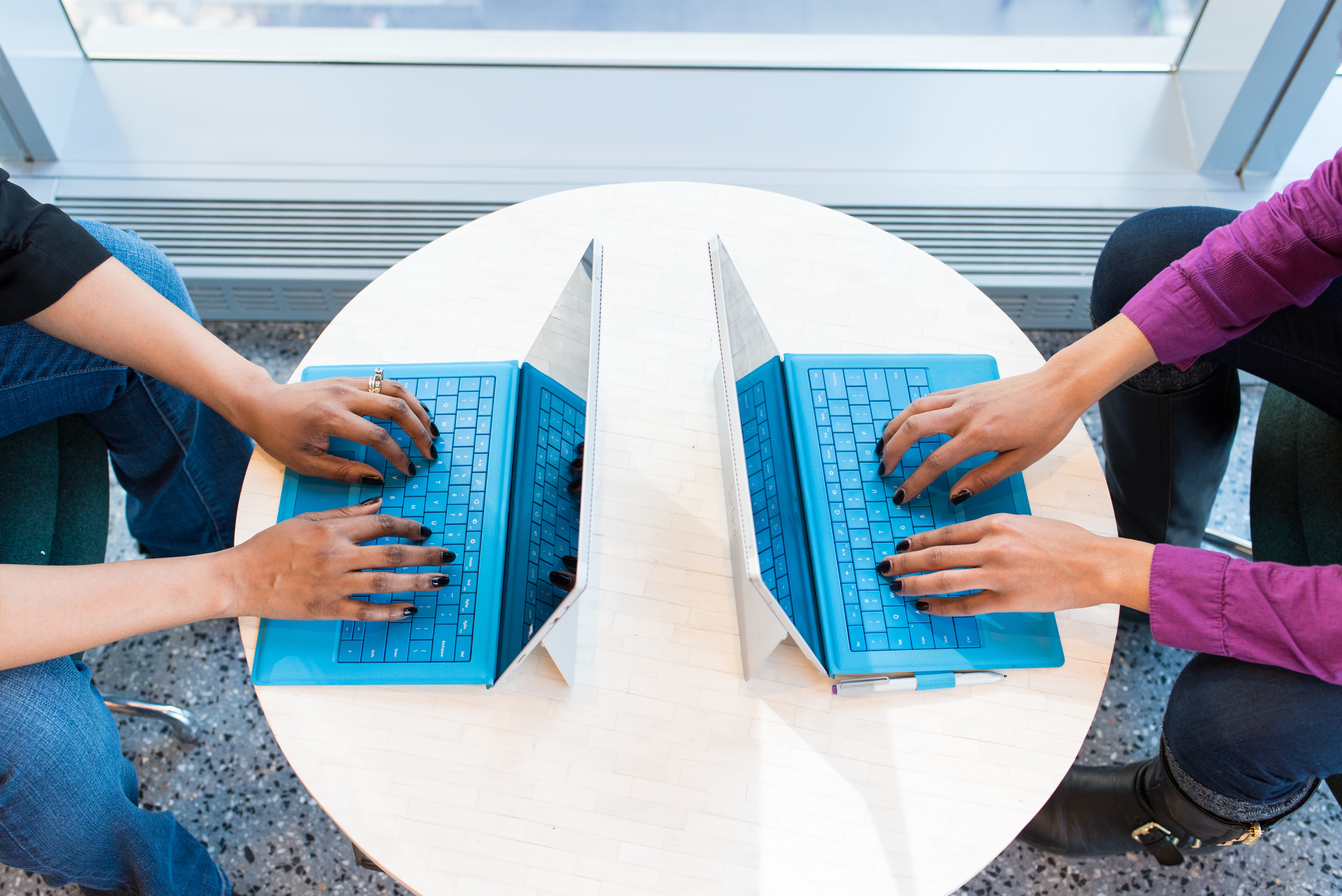 Two students typing on laptops