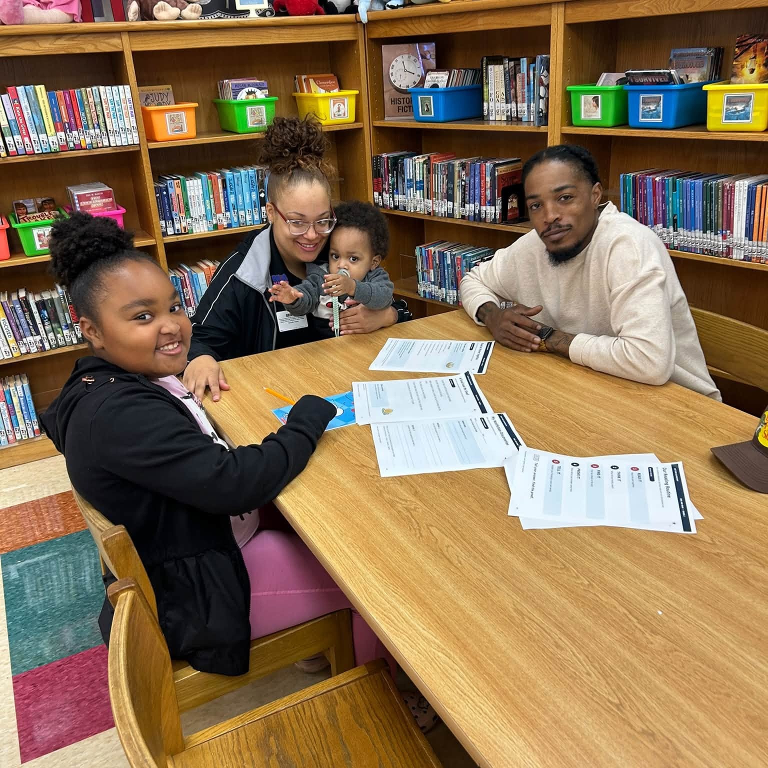 A family in the library working on main idea with her family during Read and Rise Program