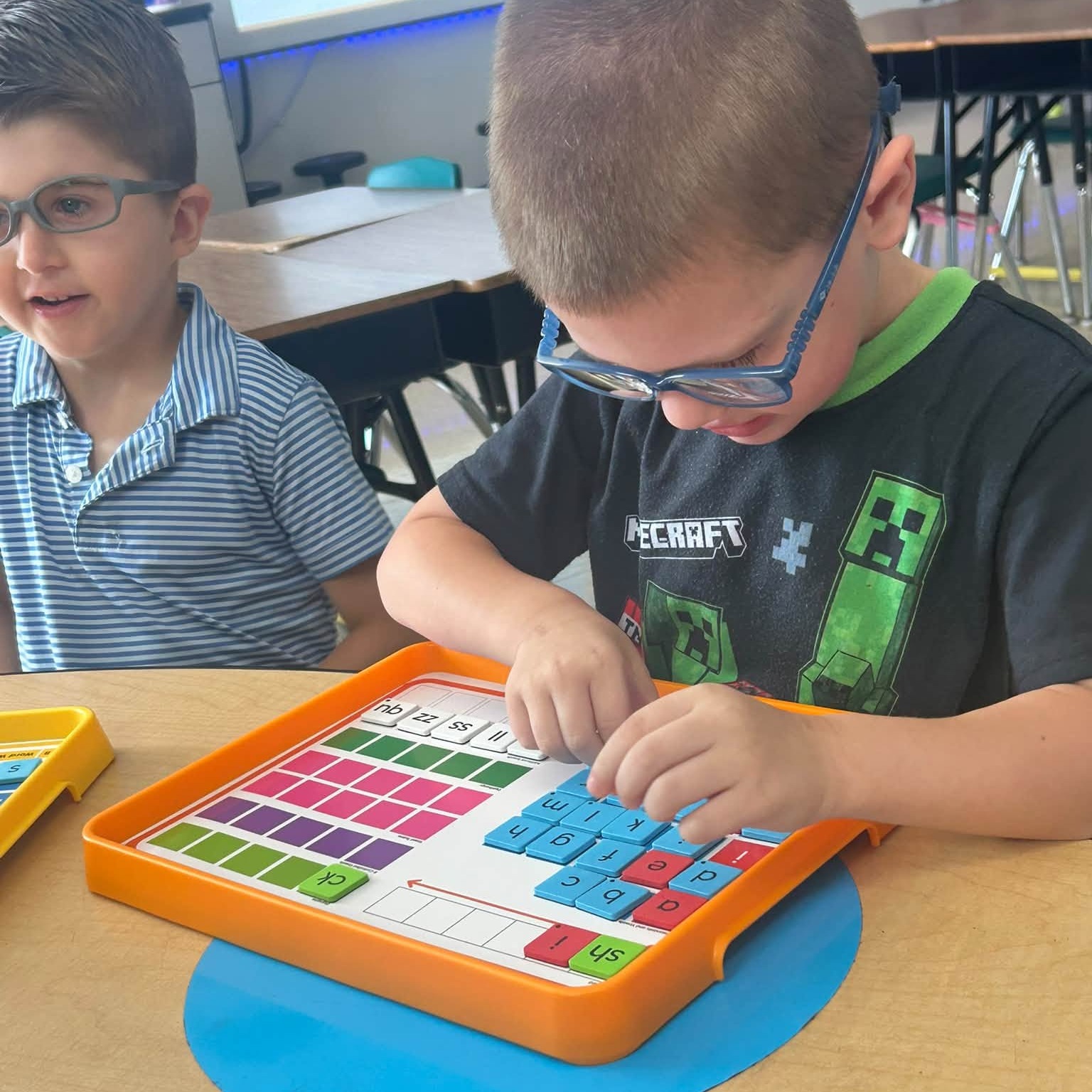 A first grade student using the blending board in the classroom to sound out words