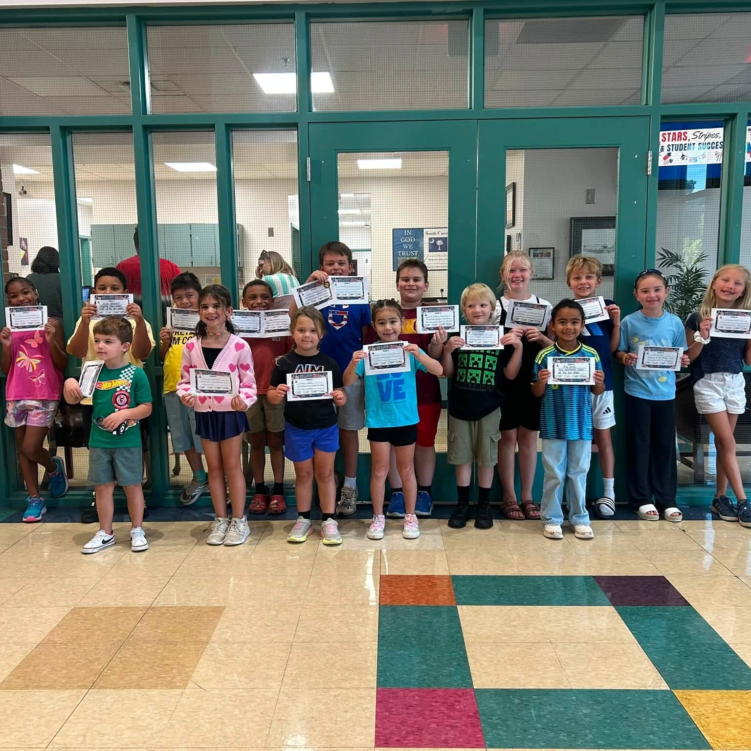 A group of East End students that earned bulldog brags standing in front of the main office with their certificates.