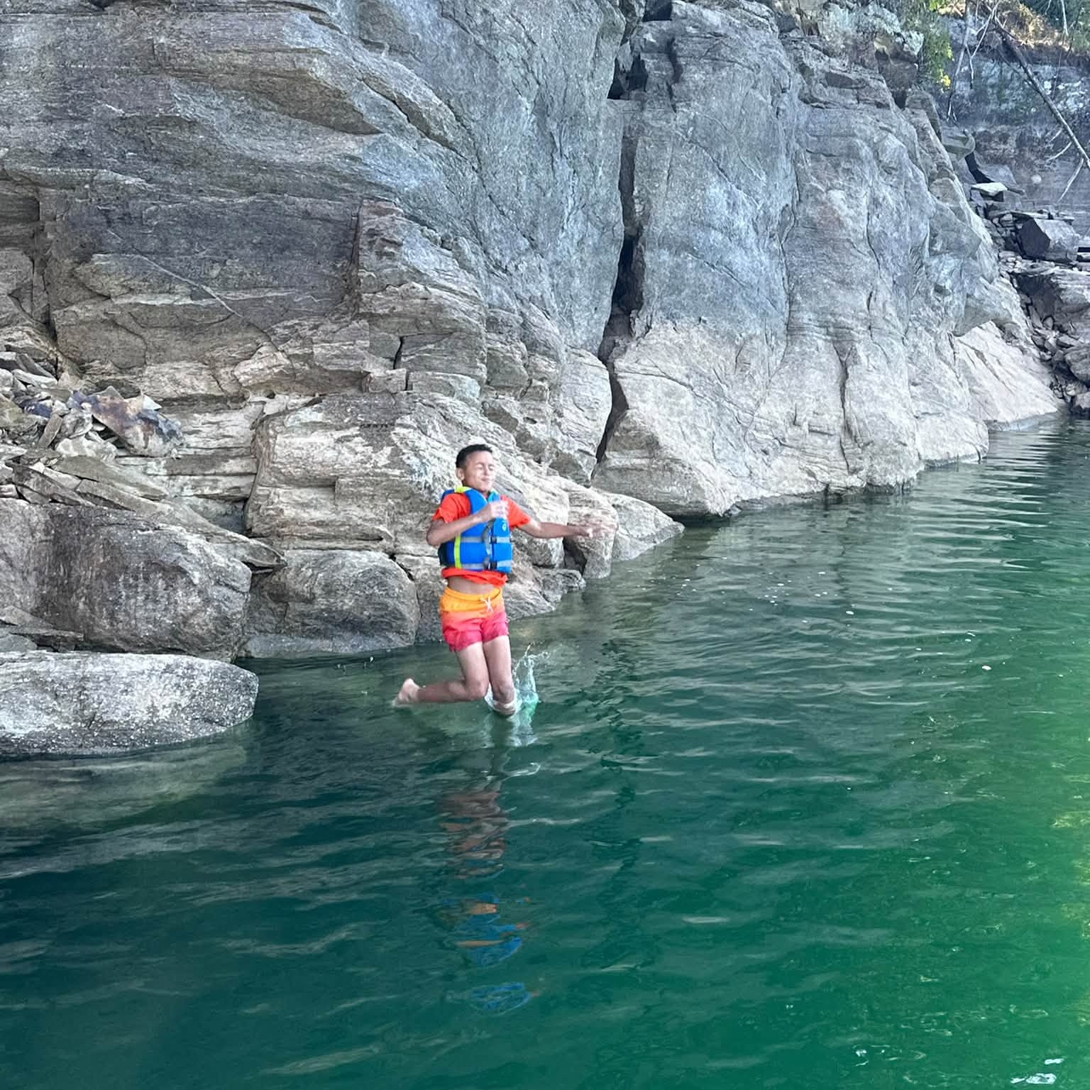 A 4th grade student jumping off the rock into Lake Jocasee during the field trip