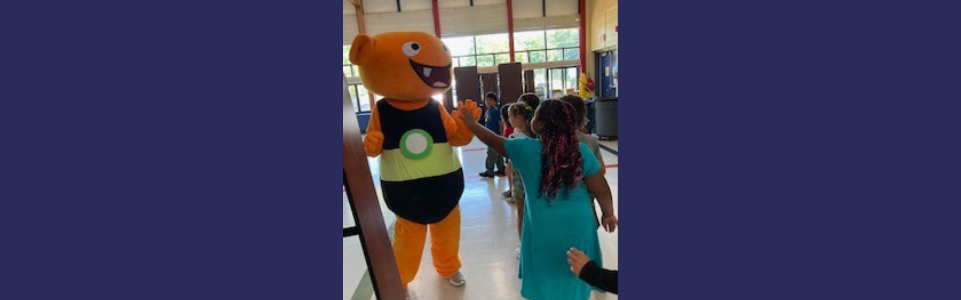 Students getting a high five from the mascot