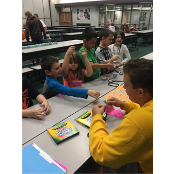 Young students using markers and crayons