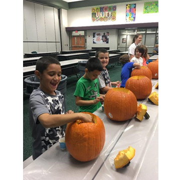 A line of students working with their pumpkins