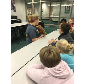 A teacher reading a book aloud to students