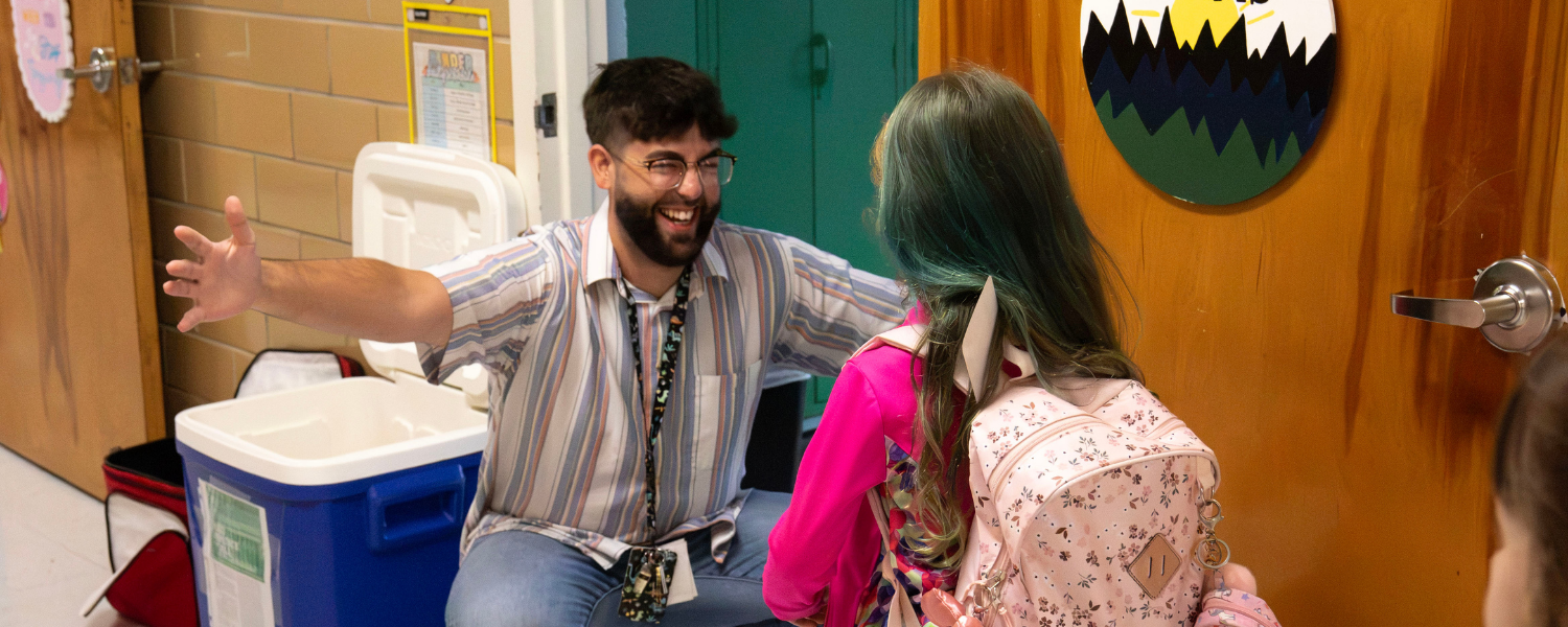 teacher greeting student at classroom door
