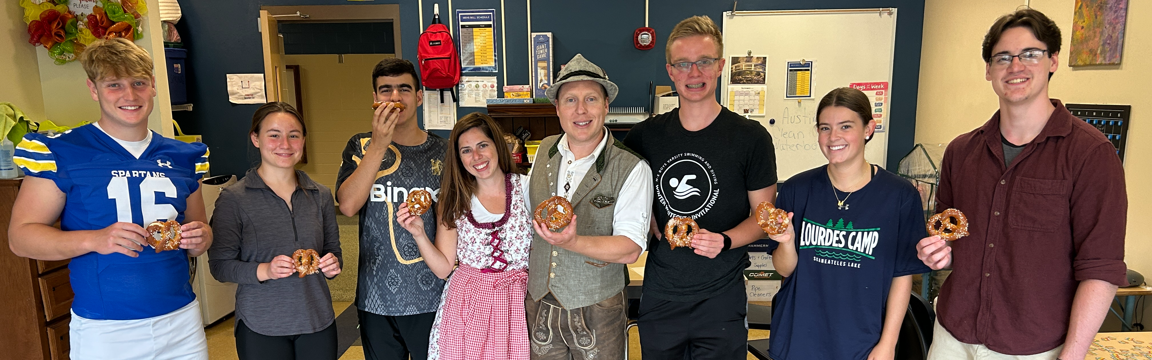 students and teachers holding pretzels 