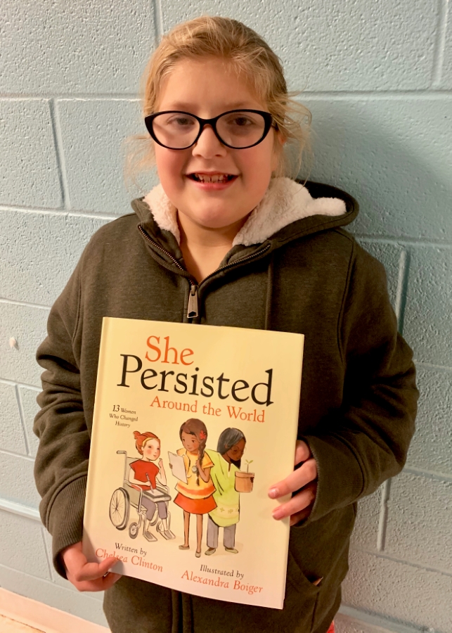 Student holding up a book