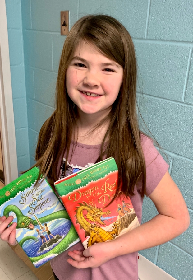 Student holding up two books