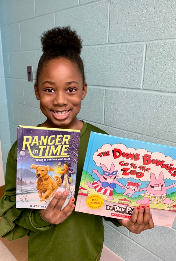 Student holding up two books