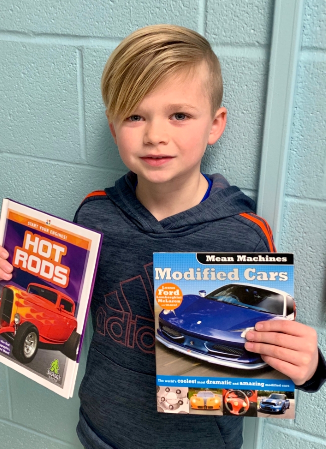 Student holding up two books