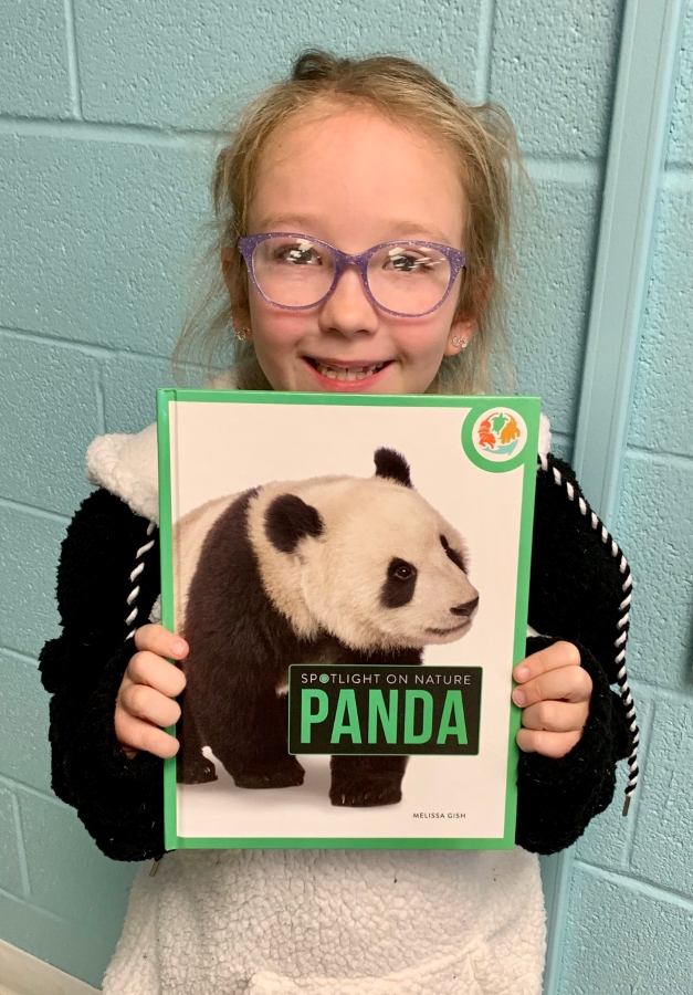 Student holding up a panda book