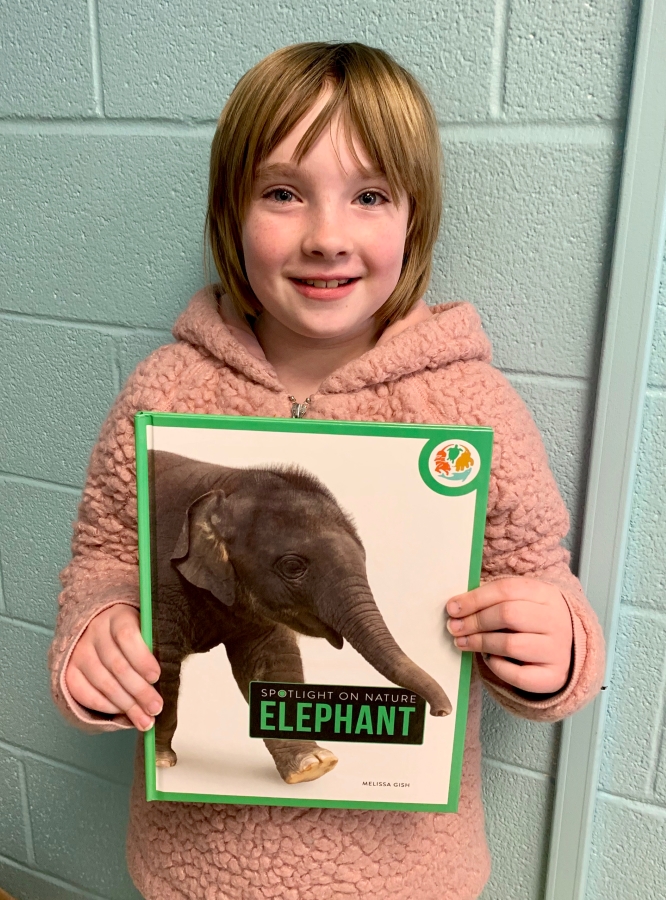 Student holding up an elephant book