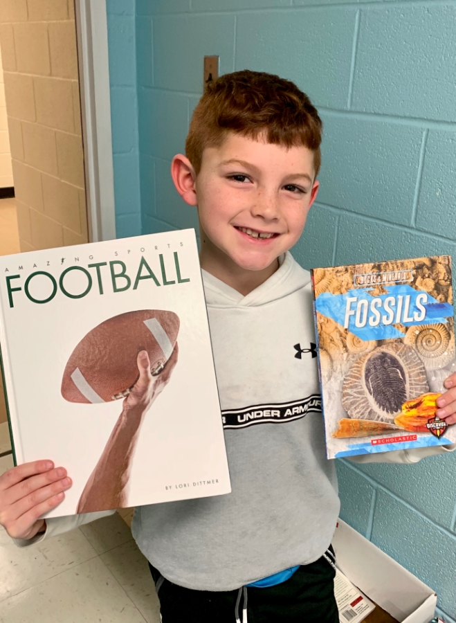 Student holding up two books