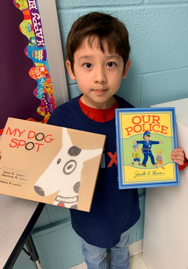 Students holding up two books