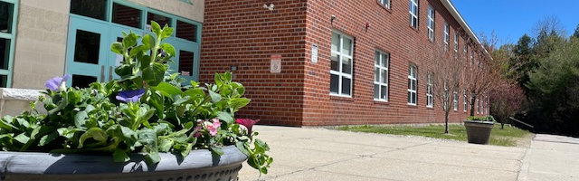 Image of the front entrance of Boynton Middle School and half of the front of the building on a summer day.