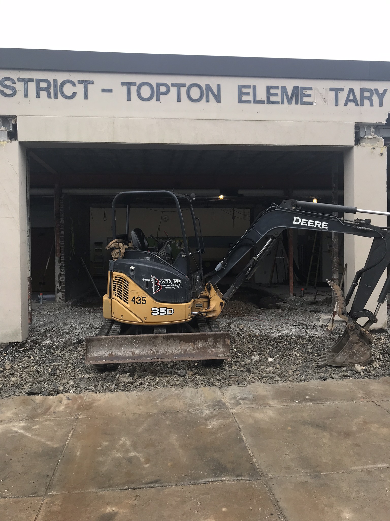Old elementary entrance - construction machine pulling up the old cement