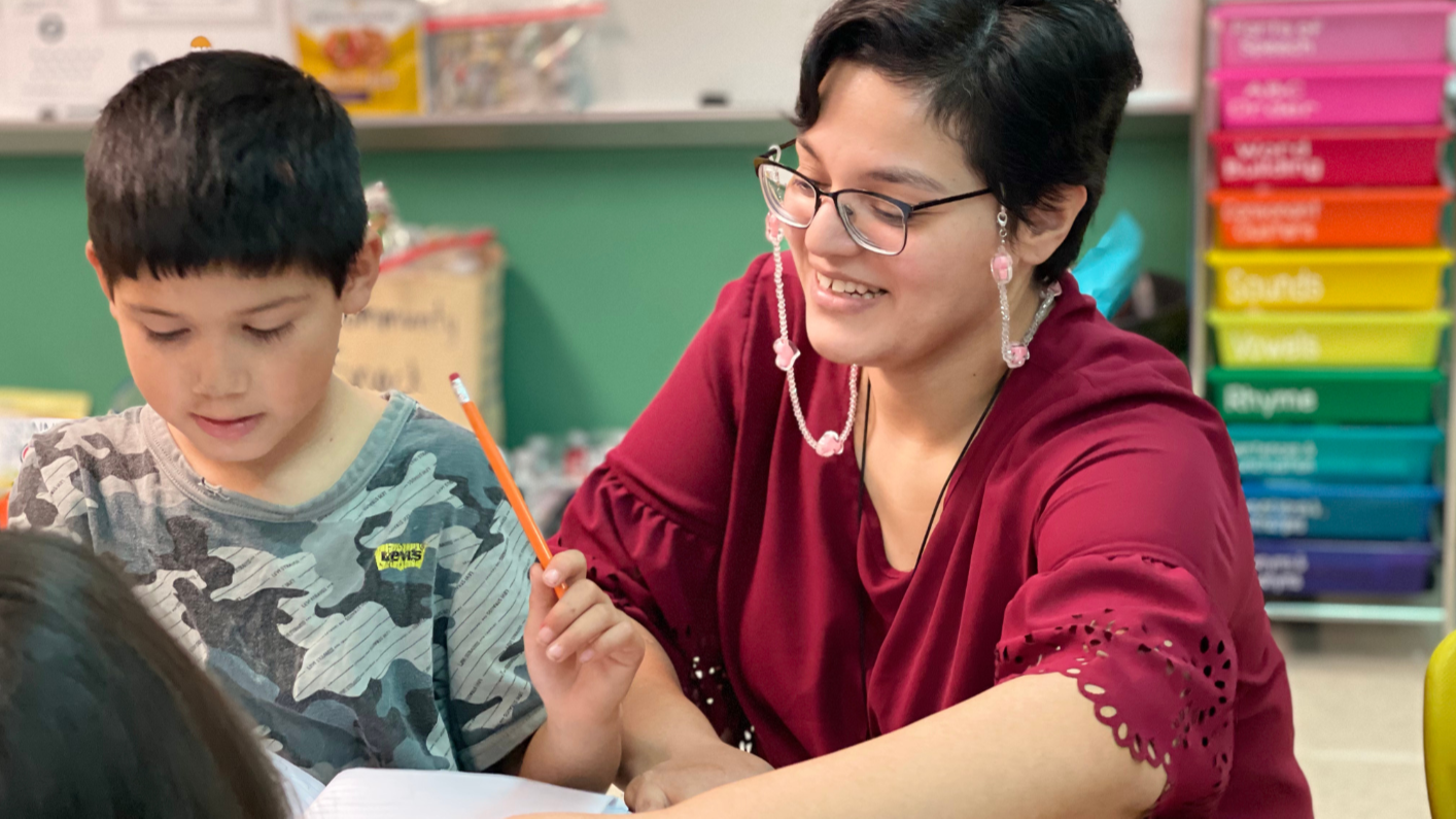 Teacher helping a student banner