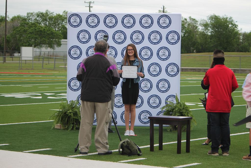 Student getting picture taken with award
