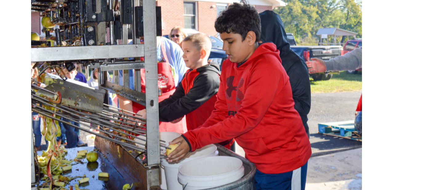 BPS Students catching the apples after the apple peeler process
