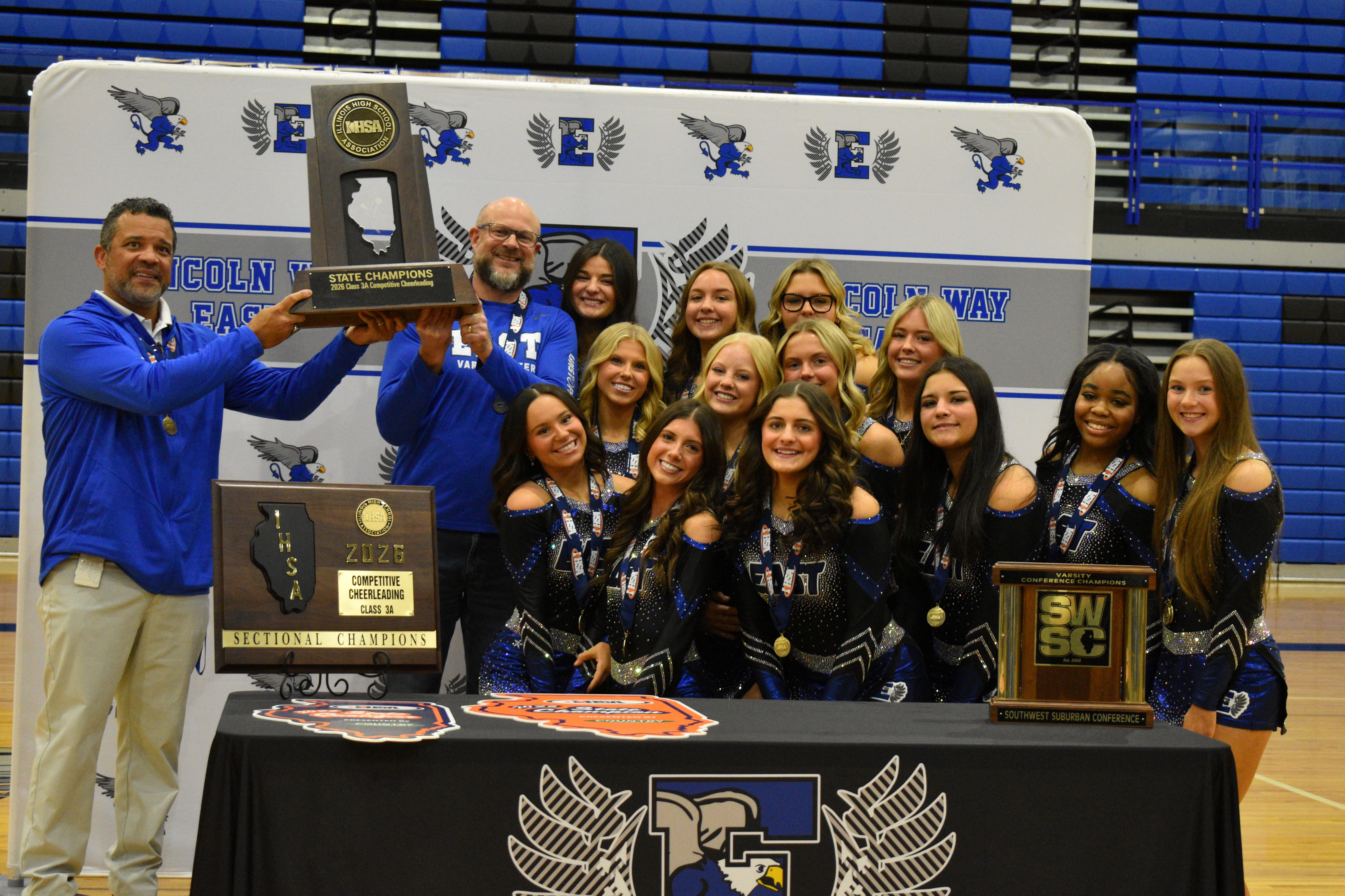 East state champion cheerleaders holding a trophy 