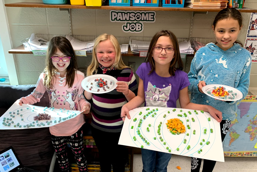 Three girls showing their projects