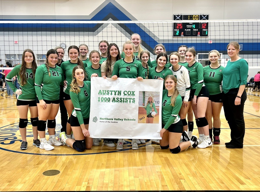 volleyball students holding sign celebrating player's achievements