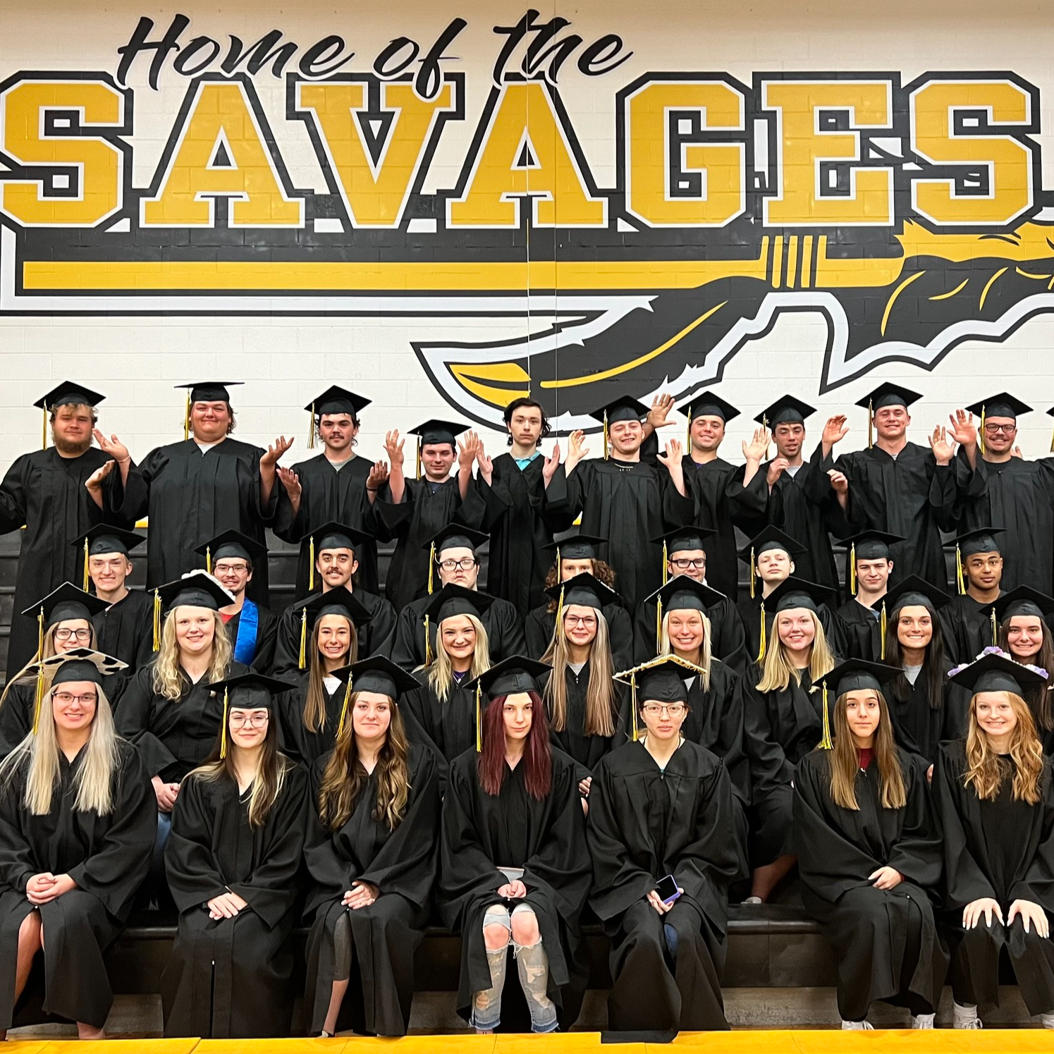 graduates pose in cap and gown