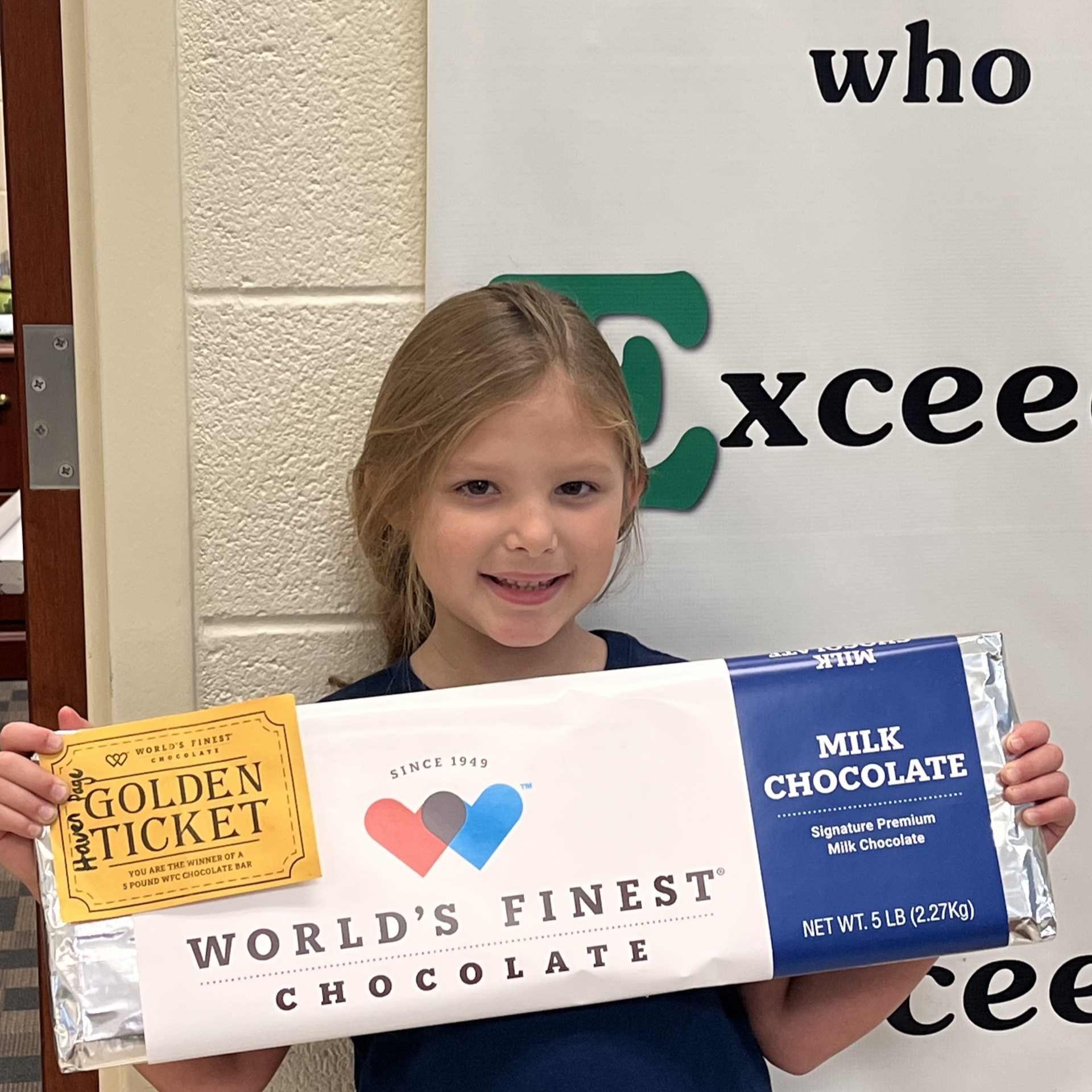 smiling girl holding a 5 pound chocolate bar