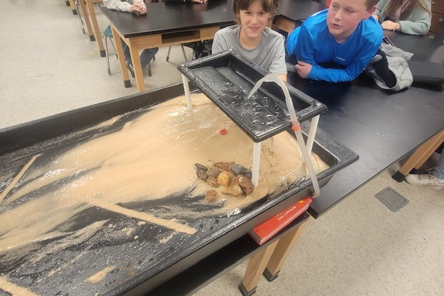 Students utilizing an erosion table