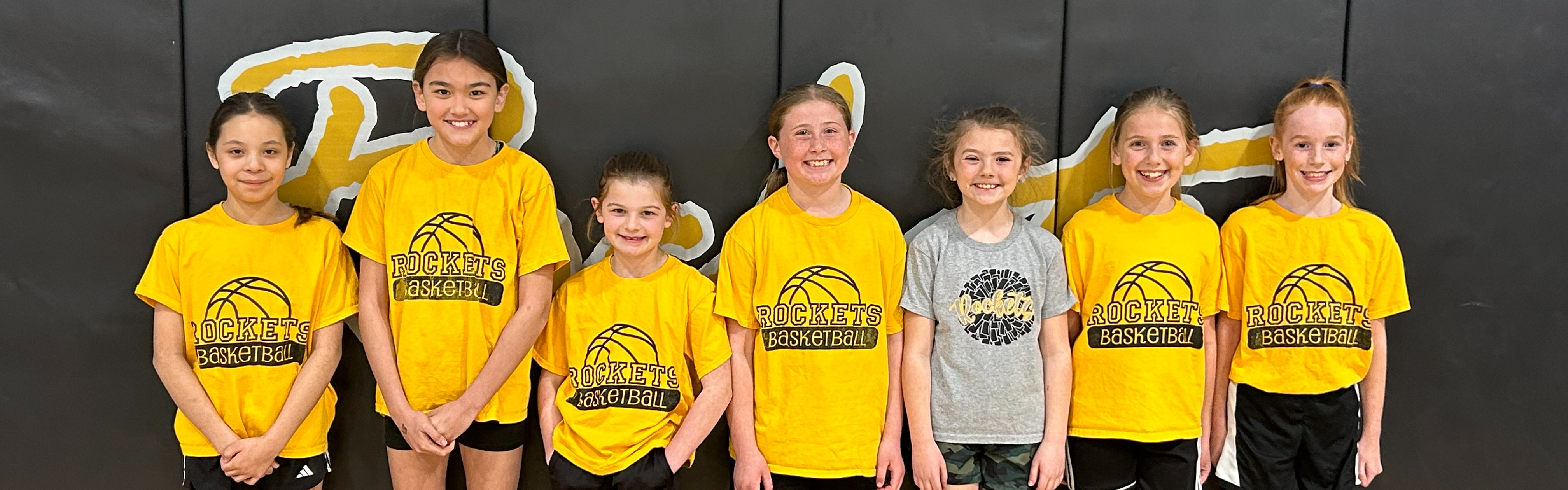 Picture of Eddyville elementary basketball girls standing against mat in high school gym