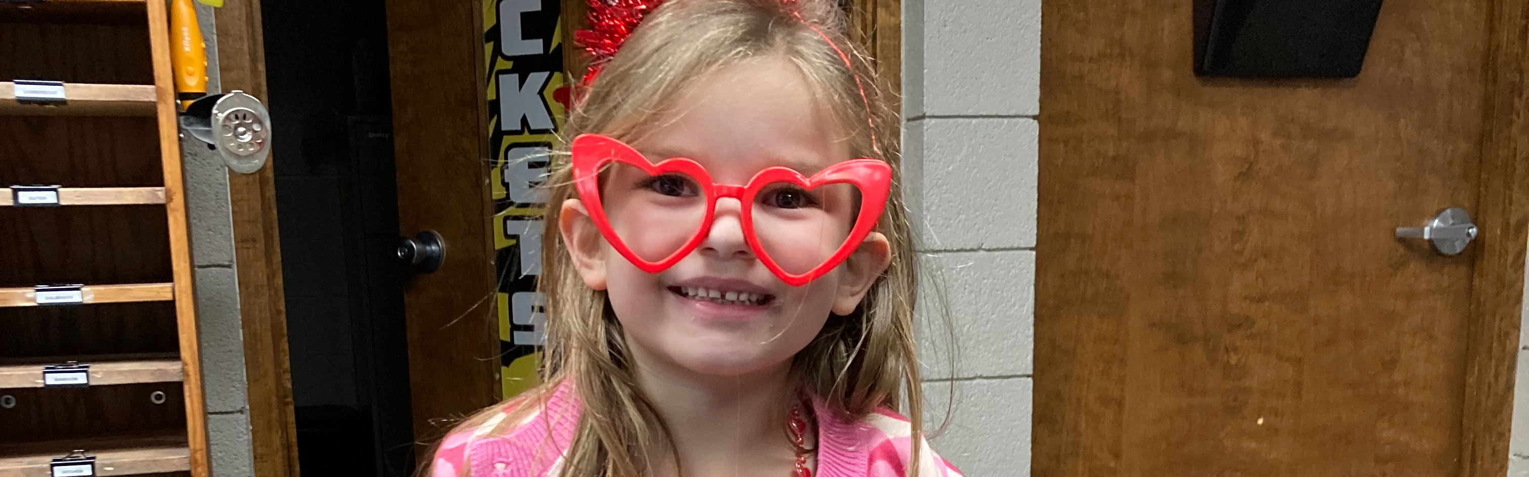 Picture of a female Eddyville student with heart sunglasses on smiling for the camera