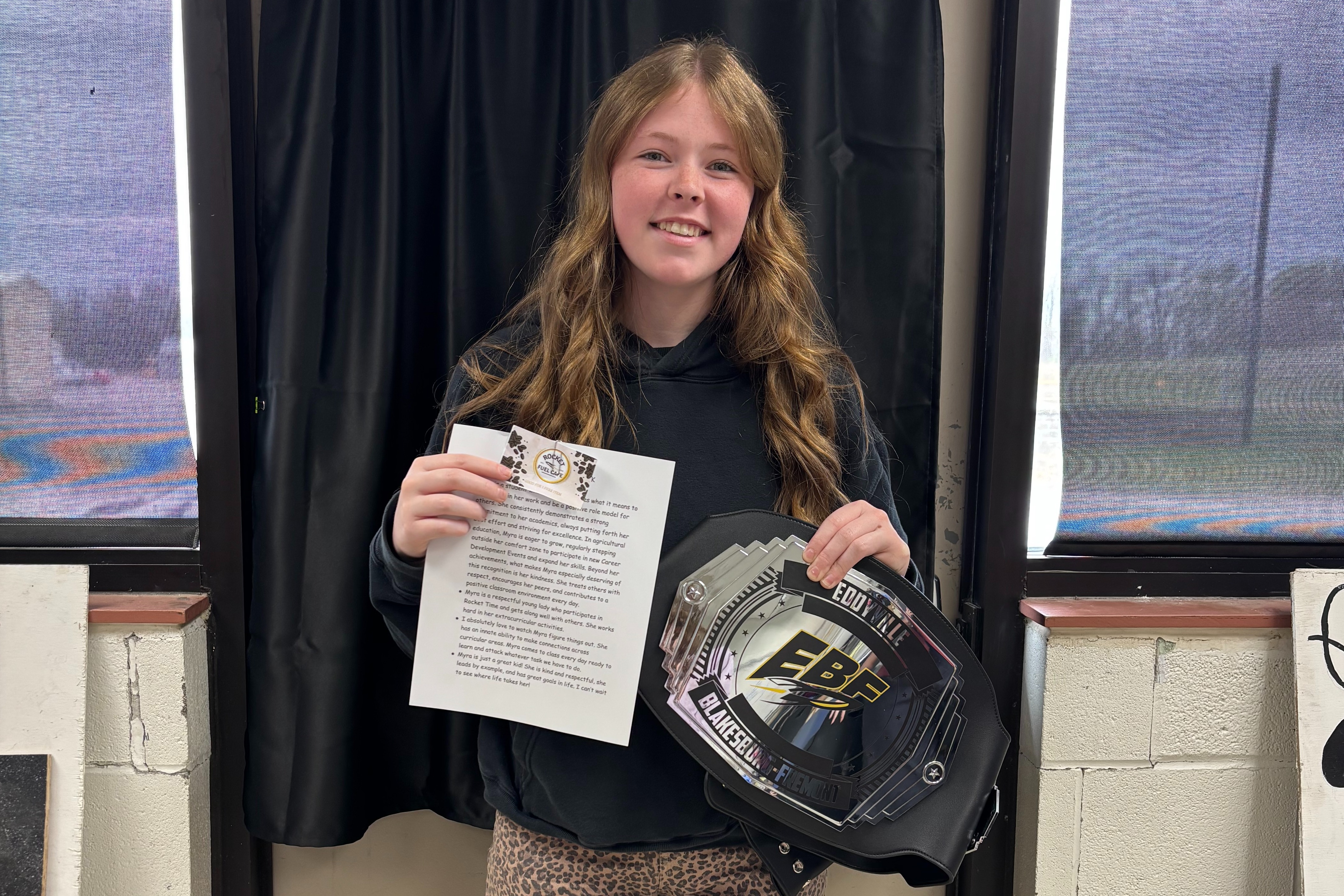 Picture of young lady holding certificate for jr./sr. high student of the week