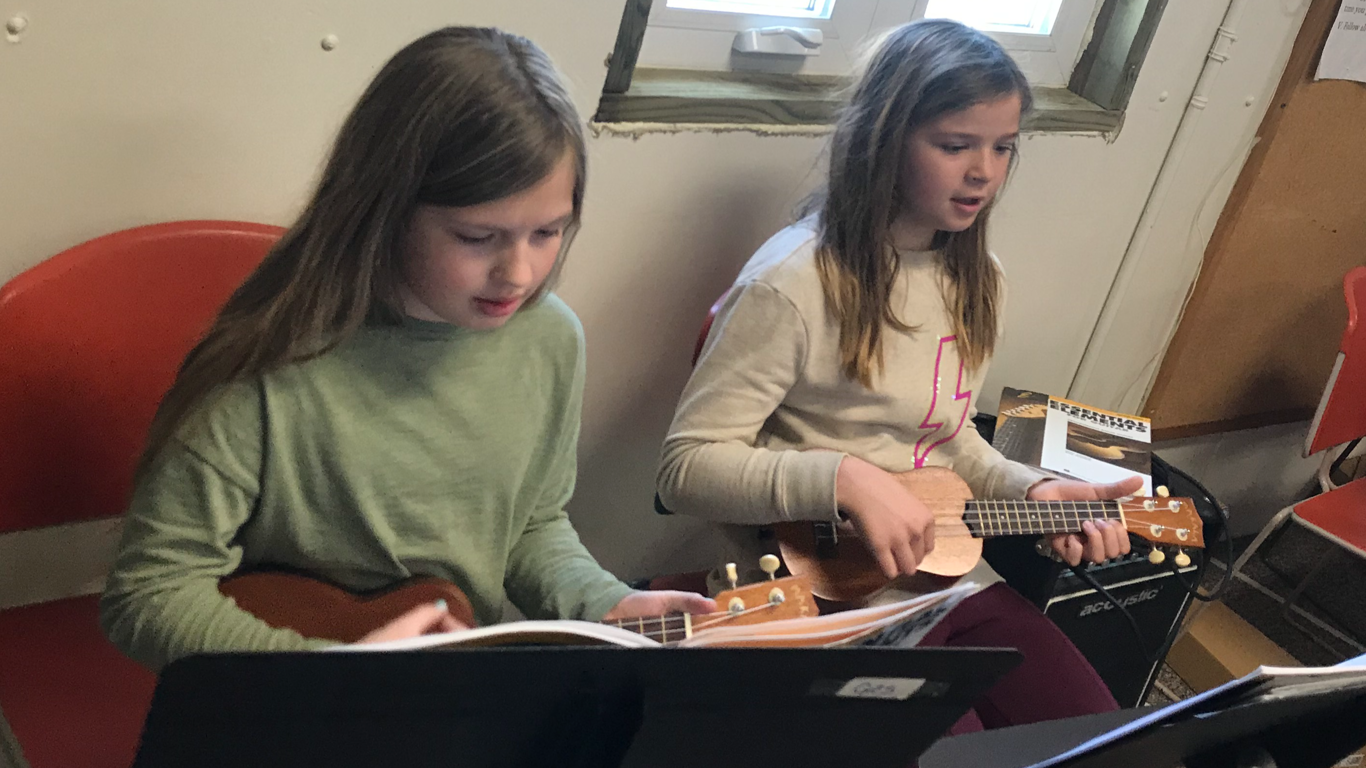 two girls practicing ukulele 