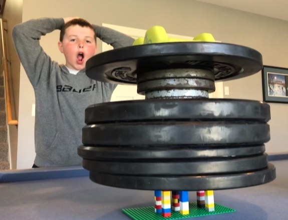 a student appears astonished by balancing weights on small lego stacks